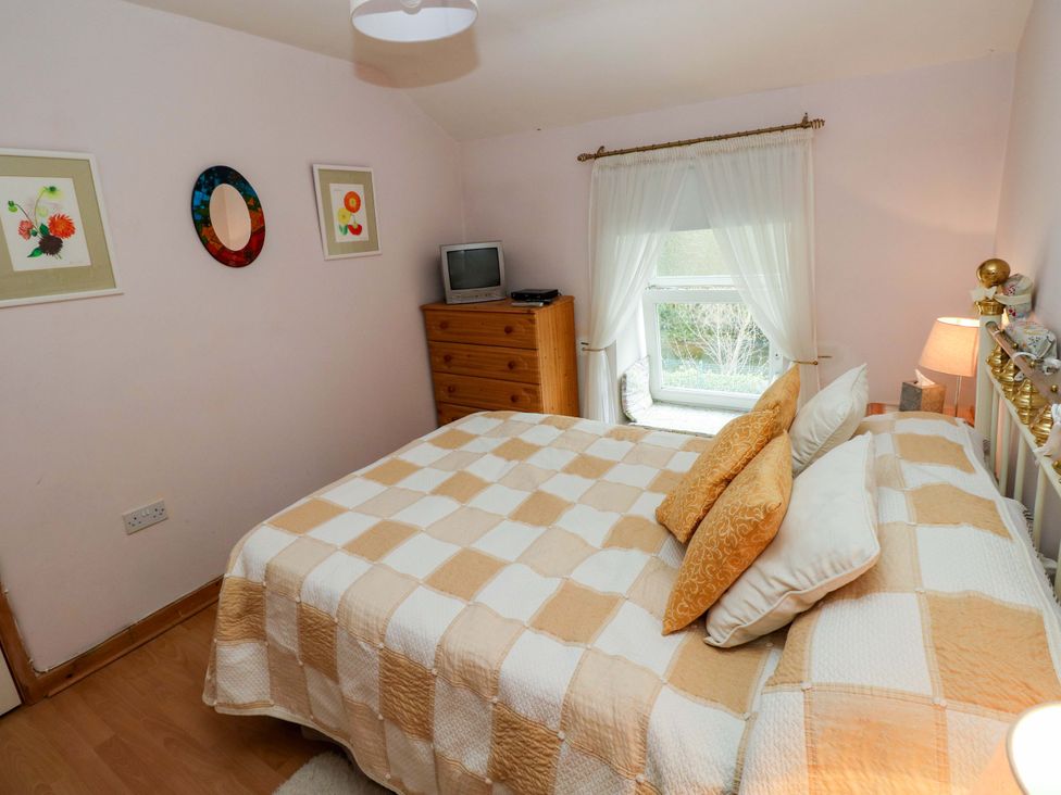 A bedroom with a bed and a dresser at Tawe Cottage in Swansea