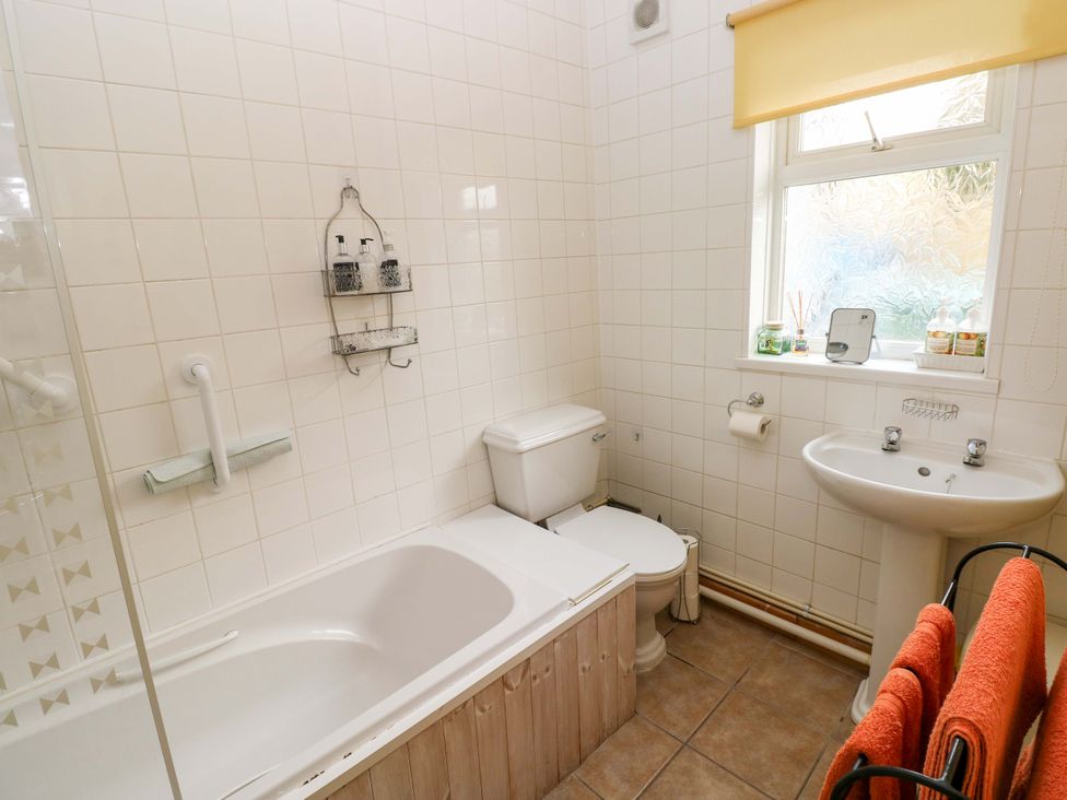 A bathroom with a bathtub, toilet, and sink at Tawe Cottage in Swansea