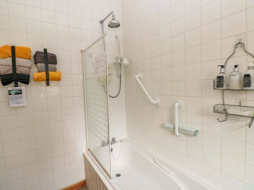 A bathroom with a bathtub and shower at Tawe Cottage Swansea