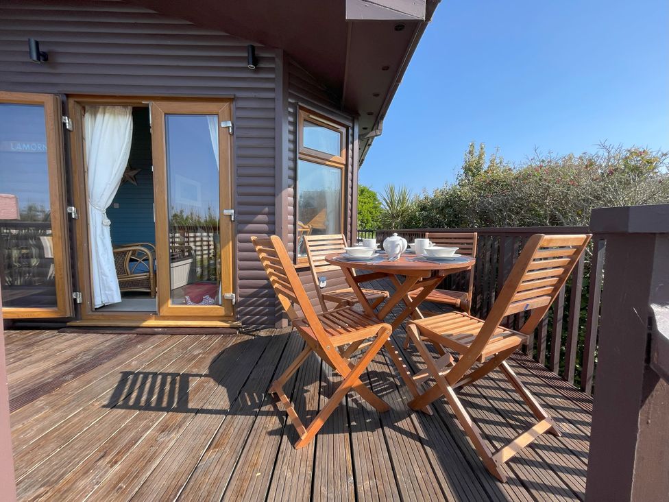 An outdoor seating area with a table and chairs at Lamorna in Sennen