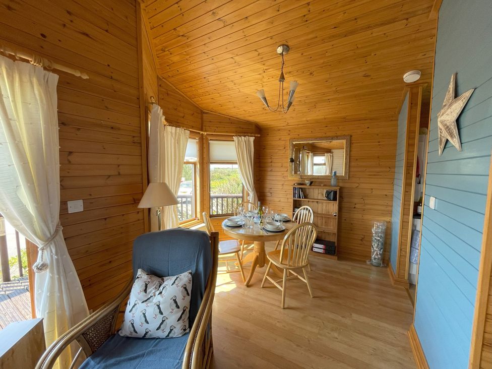 A dining room with a table and chairs at Lamorna Sennen