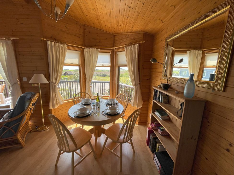 A dining room with a table set for a meal at Lamorna in Sennen