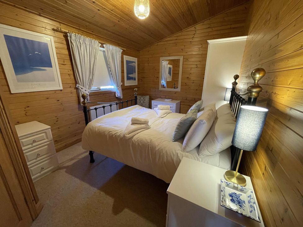 A bedroom with a bed and nightstand at Lamorna Sennen