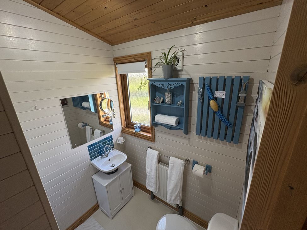 A bathroom with a sink and mirror at Lamorna in Sennen