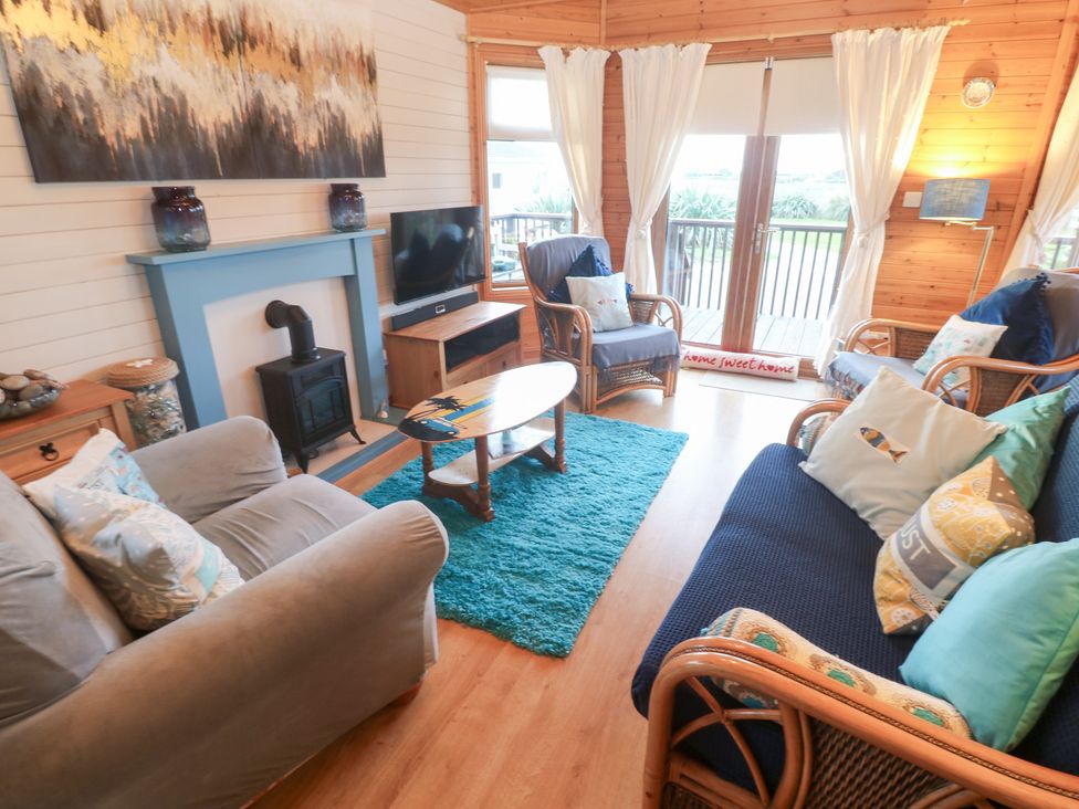 A living room with sofas and a television at Lamorna in Sennen