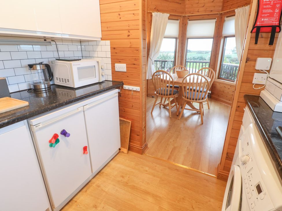 A kitchen with appliances and a dining area at Lamorna in Sennen