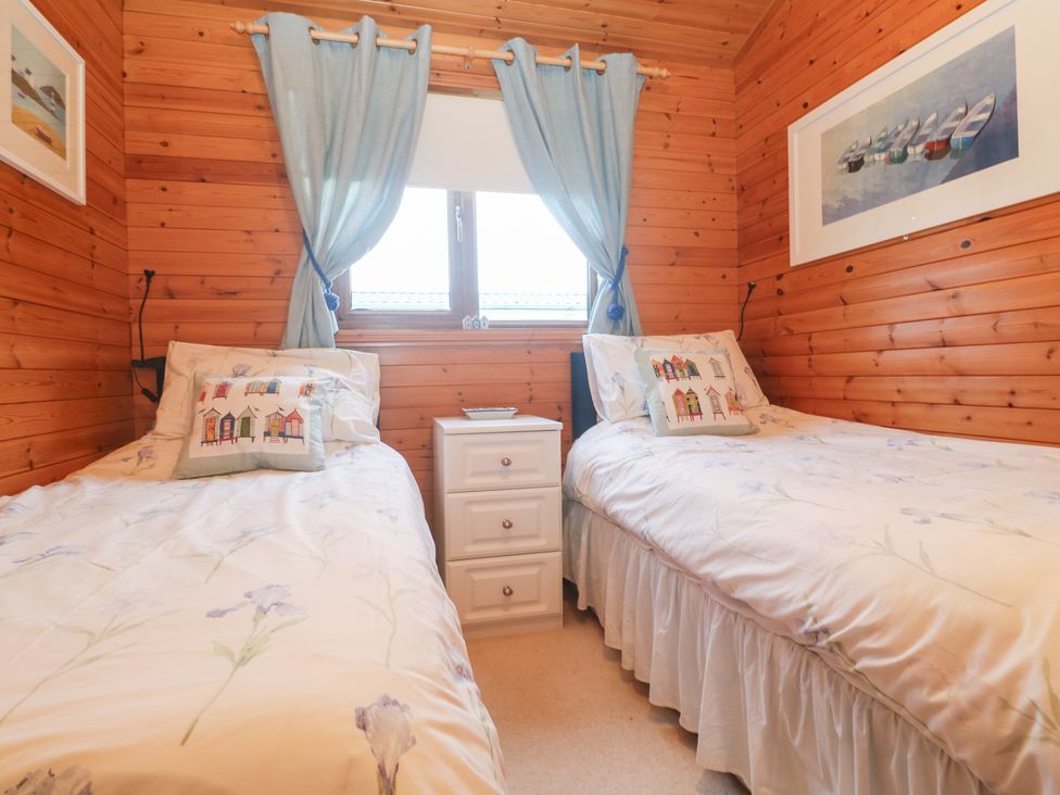 A bedroom with two single beds and a nightstand at Lamorna Sennen