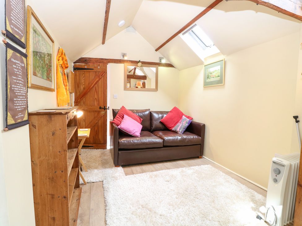A snug with a sofa and shelf at The Retreat in Norwich