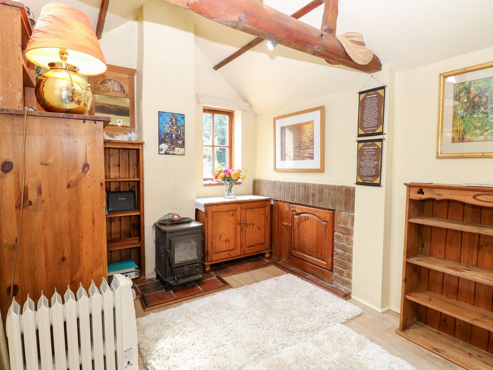 A snug with wooden furniture and a stove at The Retreat in Norwich