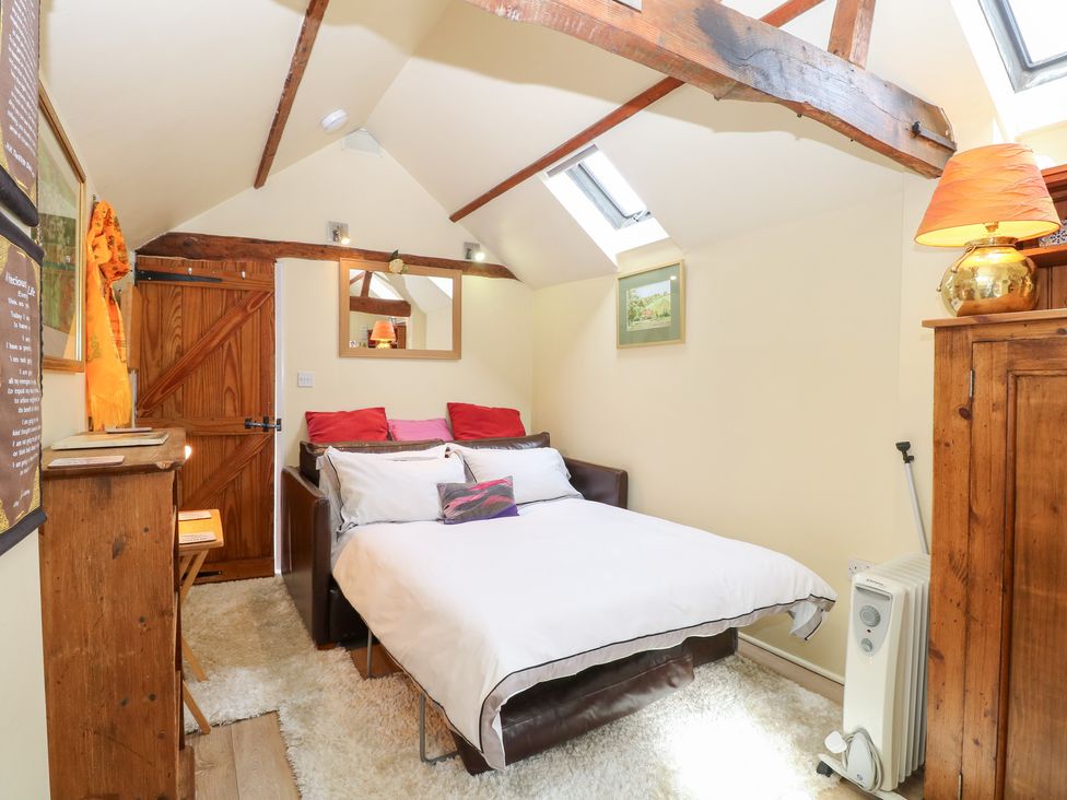 A bedroom with a bed and wardrobe at The Retreat in Norwich