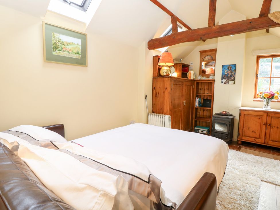 A bedroom with a bed and wooden furniture at The Retreat in Norwich