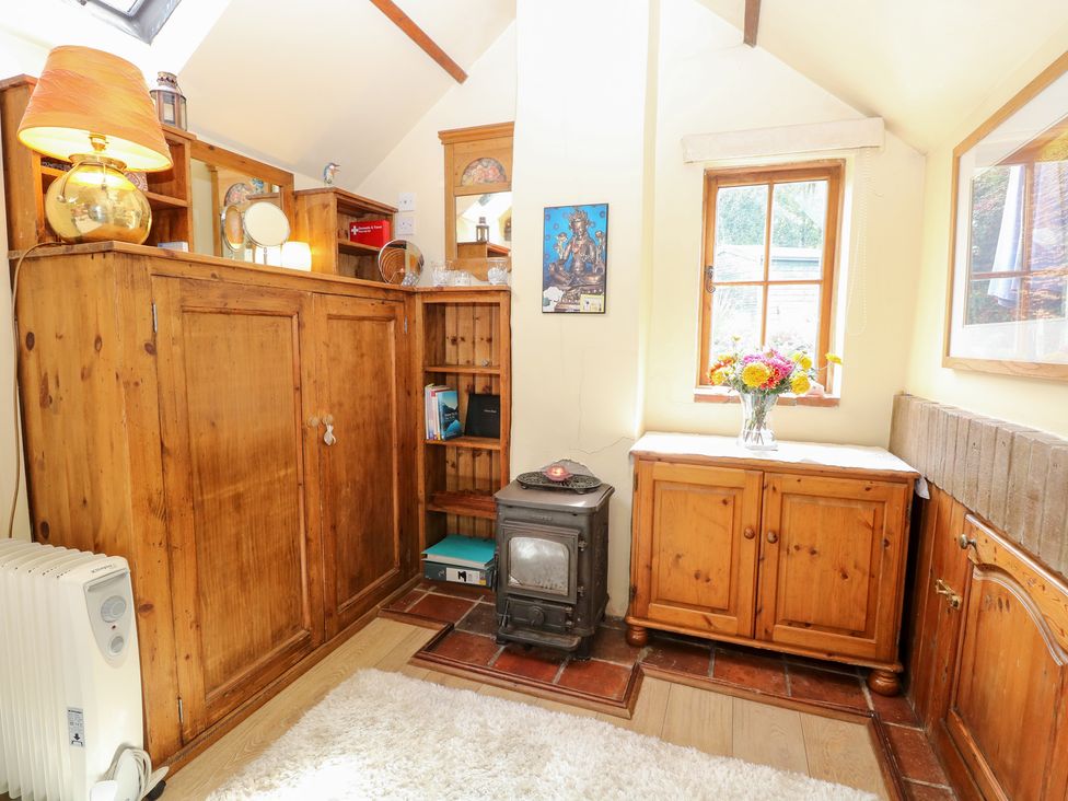 A snug with wooden furniture and a stove at The Retreat in Norwich