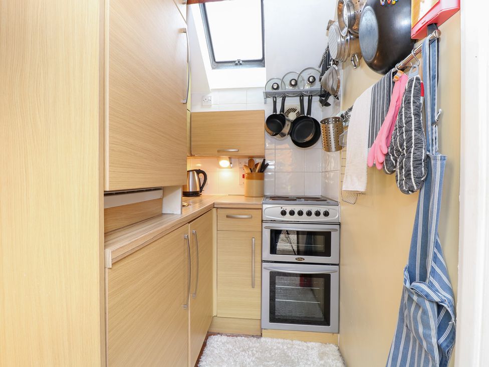 A kitchen with cabinets, oven, stove, and cookware at The Retreat in Norwich