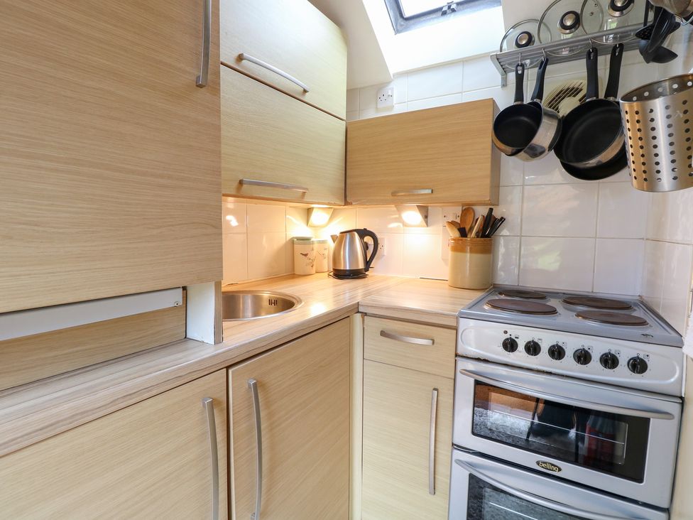 A kitchen with cabinets and stove at The Retreat in Norwich
