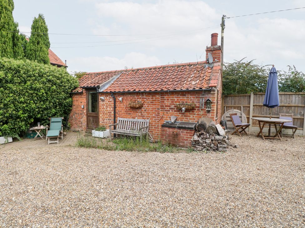 An outdoor area with a brick building and seating at The Retreat in Norwich
