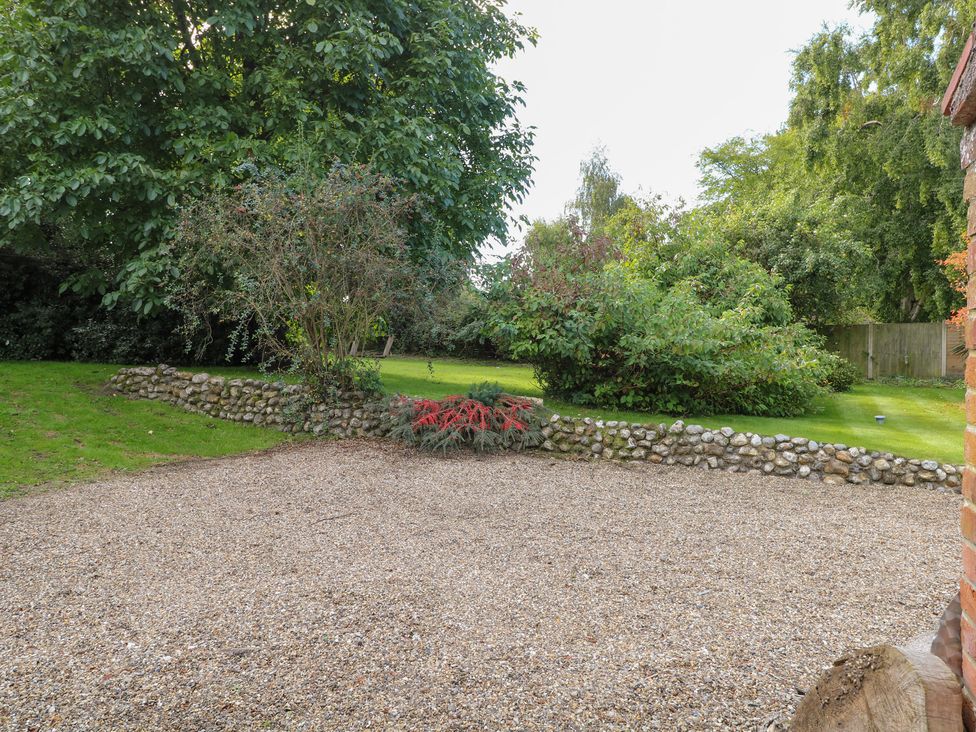 A garden with gravel area and surrounding trees at The Retreat in Norwich
