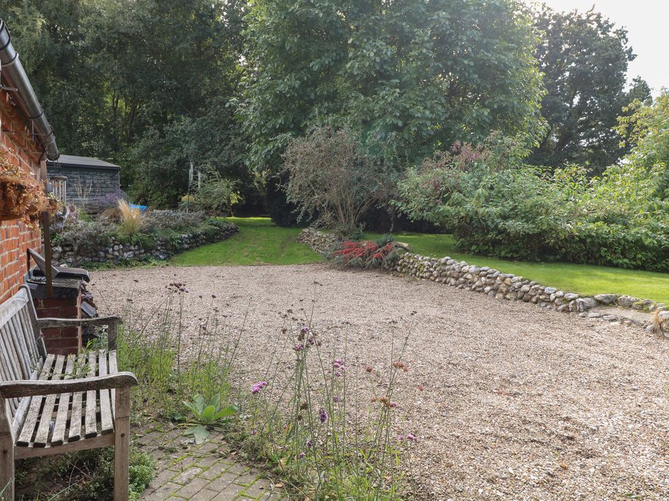 A garden area with a bench and gravel path at The Retreat in Norwich