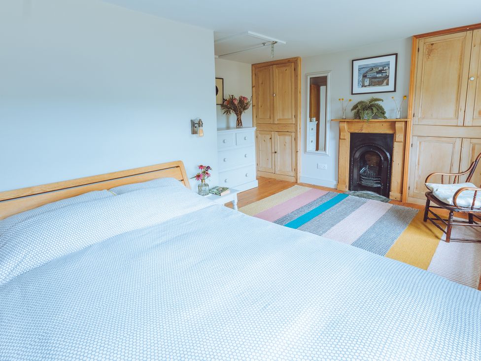 A bedroom with a bed and dresser at Treovis Cottage in Callington