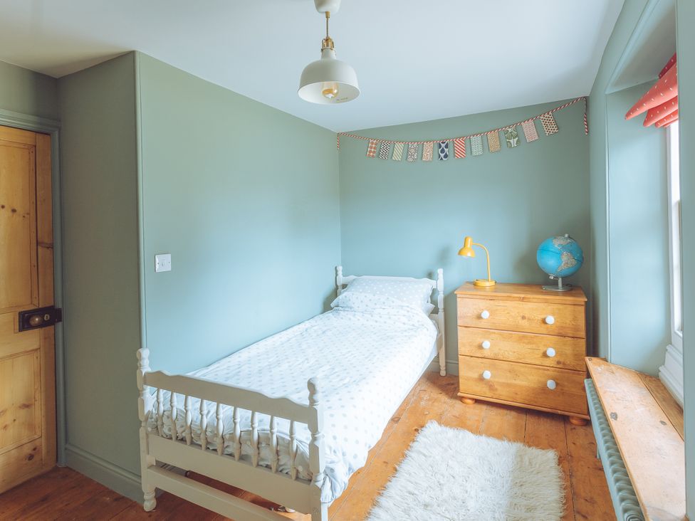 A bedroom with bed and dresser at Treovis Cottage in Callington