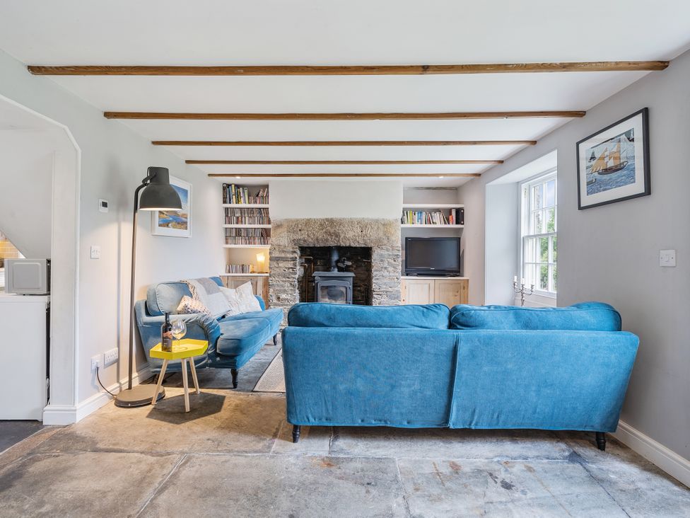 A living room with a sofa and a fireplace at Treovis Cottage Callington