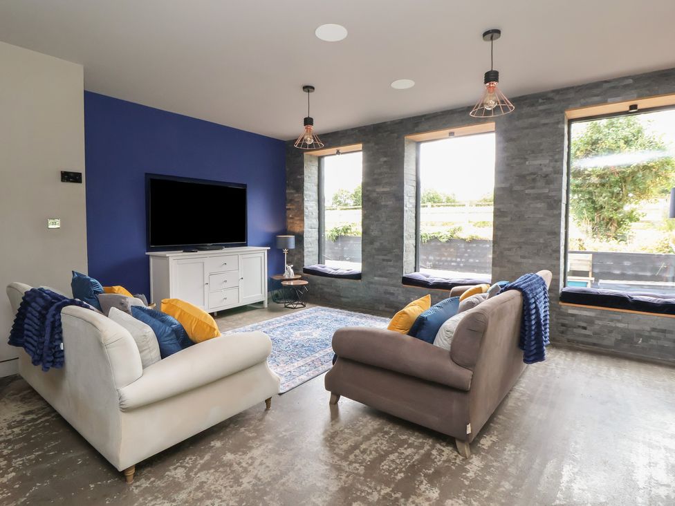 A living room with a television and two sofas at Rook Hall Farm in Newcastle