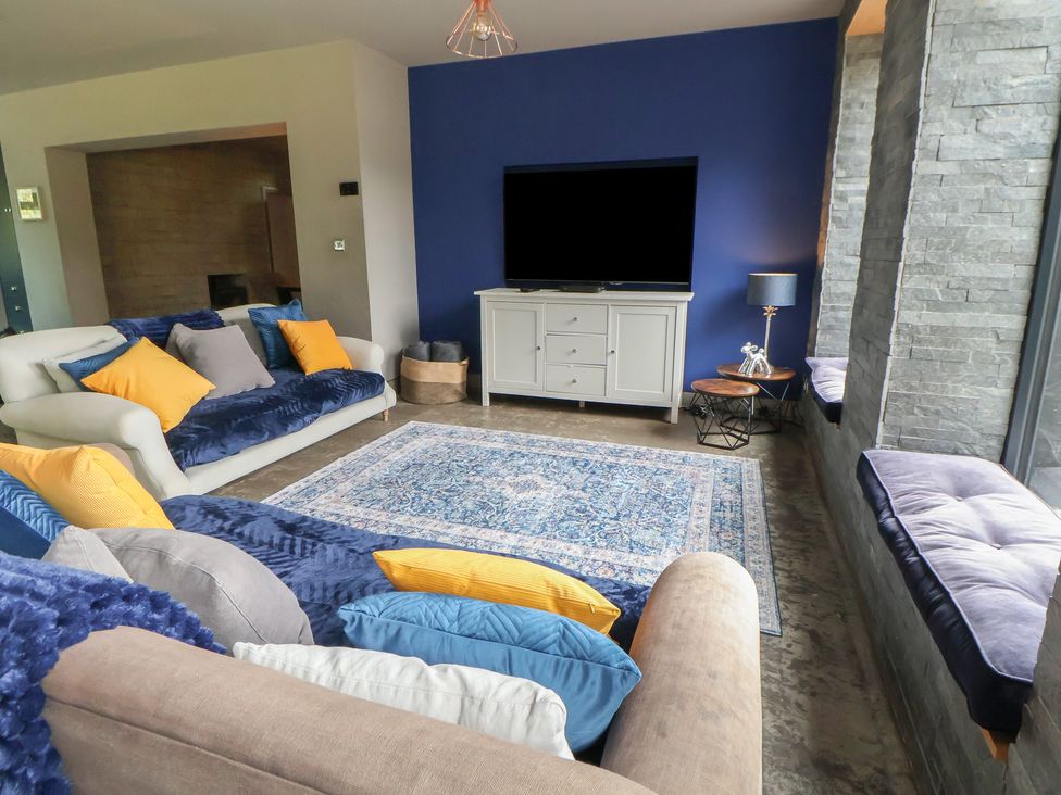 A living room with a television and sofa at Rook Hall Farm in Newcastle