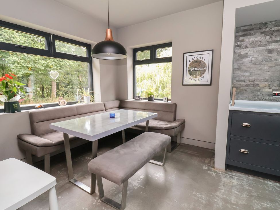 A dining room with a table and benches at Rook Hall Farm in Newcastle