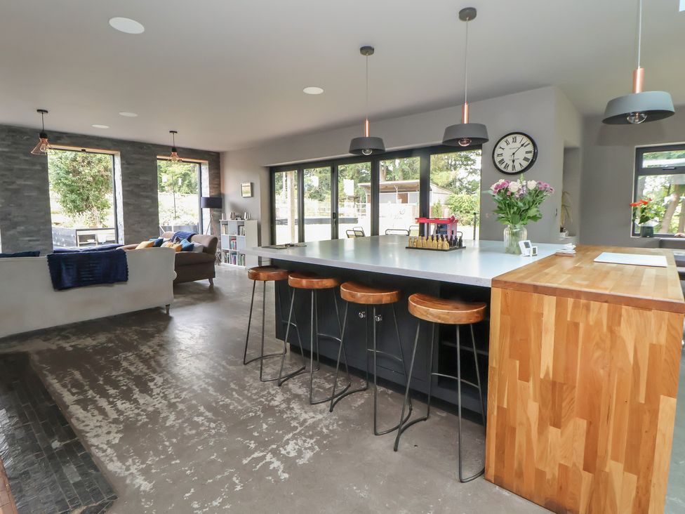A kitchen with a bar counter and stools at Rook Hall Farm Newcastle