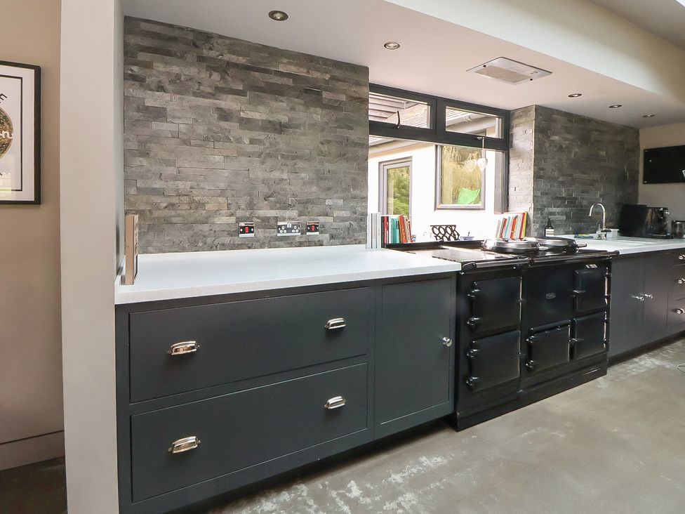 A kitchen with dark cabinets and a cooktop at Rook Hall Farm Newcastle