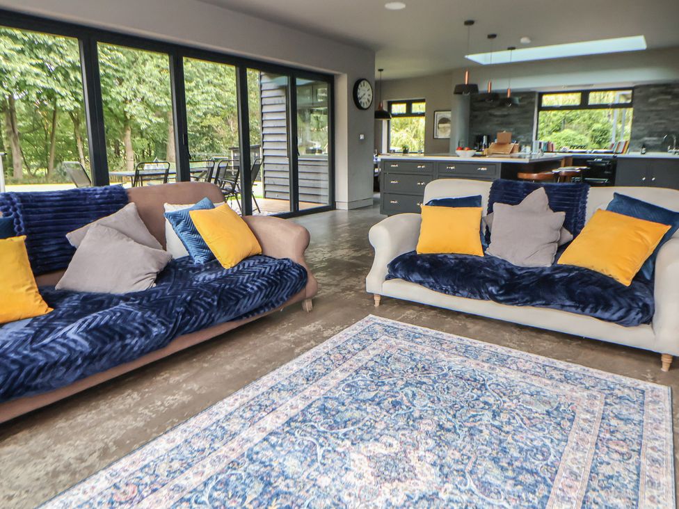 A living room with sofas and a view of the kitchen at Rook Hall Farm Butterton near Newcastle-Under-Lyme