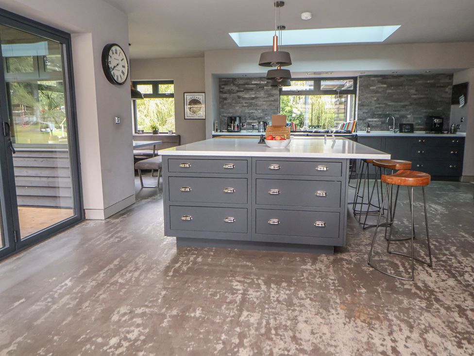 A kitchen with an island and bar stools at Rook Hall Farm in Butterton near Newcastle-Under-Lyme