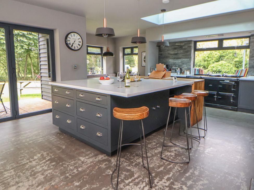 A kitchen with an island and bar stools at Rook Hall Farm Butterton near Newcastle-Under-Lyme