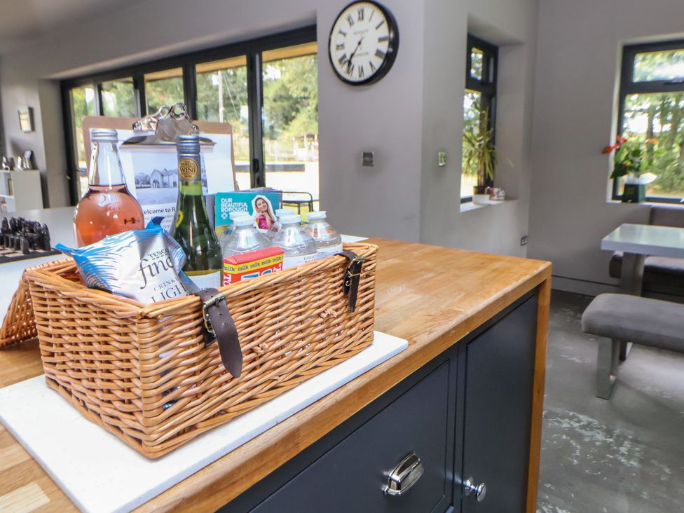 A kitchen with a basket of drinks and a clock at Rook Hall Farm in Butterton near Newcastle-Under-Lyme