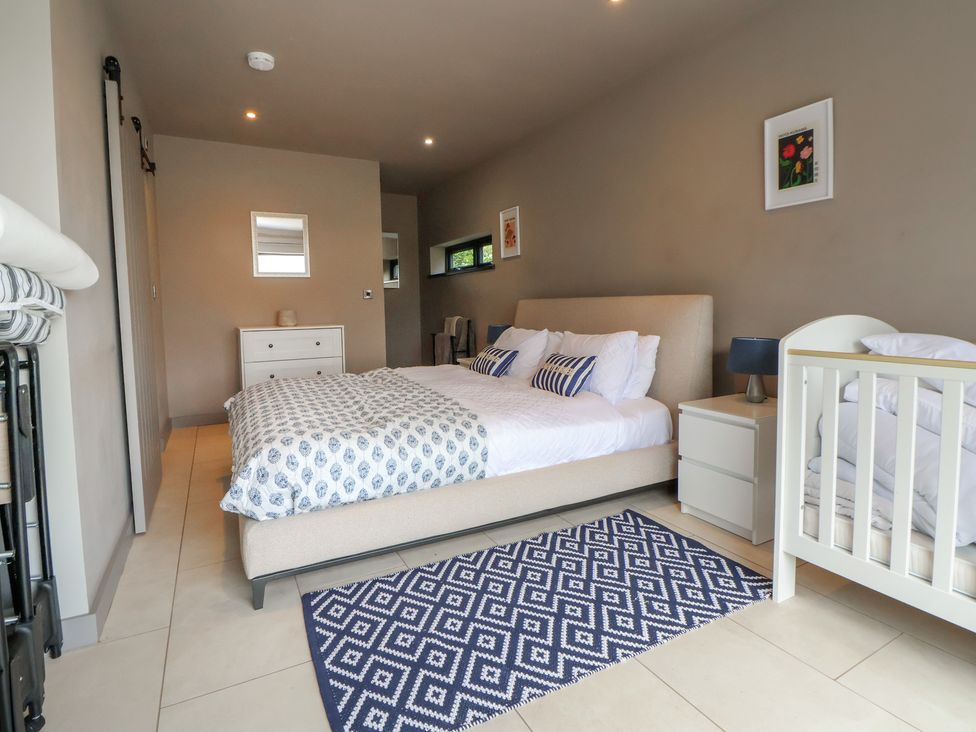 A bedroom with a bed and a crib at Rook Hall Farm in Butterton near Newcastle-Under-Lyme