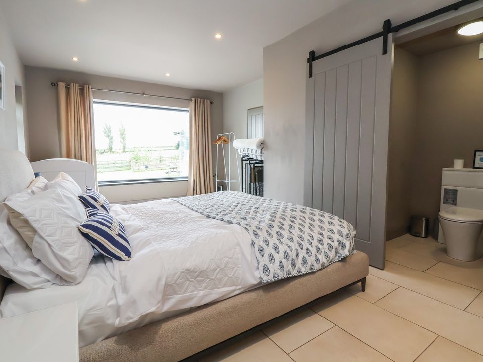 A bedroom with a bed and sliding door at Rook Hall Farm Butterton near Newcastle-Under-Lyme