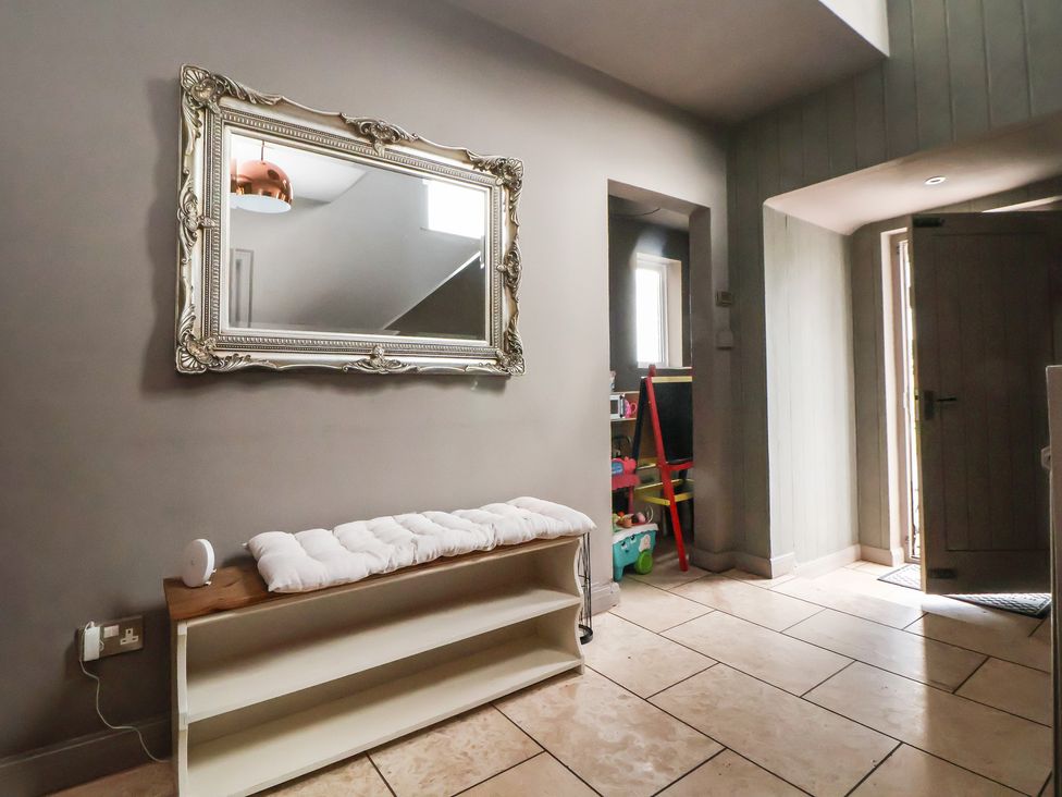 An entrance hall featuring a mirror, bench, and shelf with toys at Rook Hall Farm in Butterton near Newcastle-Under-Lyme