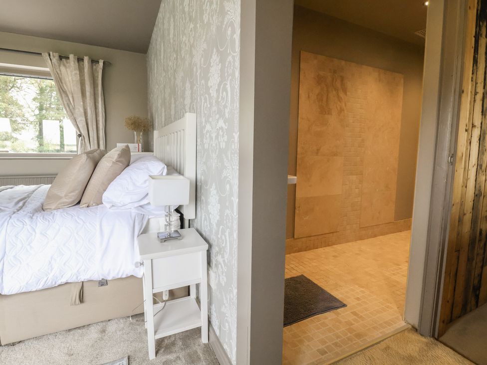 A bedroom with a bed and adjacent shower area at Rook Hall Farm Butterton near Newcastle-Under-Lyme