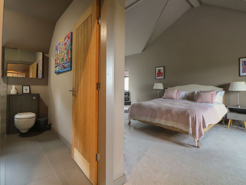 A bedroom with a bed and a toilet in an adjoining space at Rook Hall Farm Butterton near Newcastle-Under-Lyme