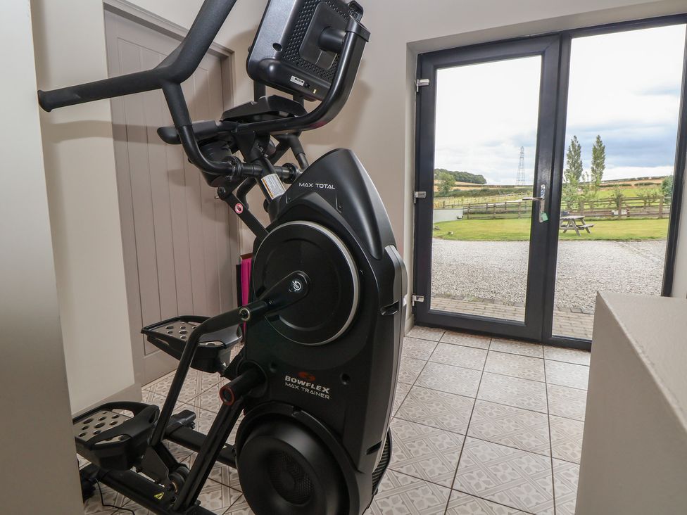 An elliptical trainer near a door with outdoor view at Rook Hall Farm, Butterton near Newcastle-Under-Lyme