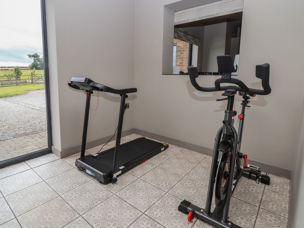 A gym with a treadmill and exercise bike at Rook Hall Farm Butterton near Newcastle-Under-Lyme