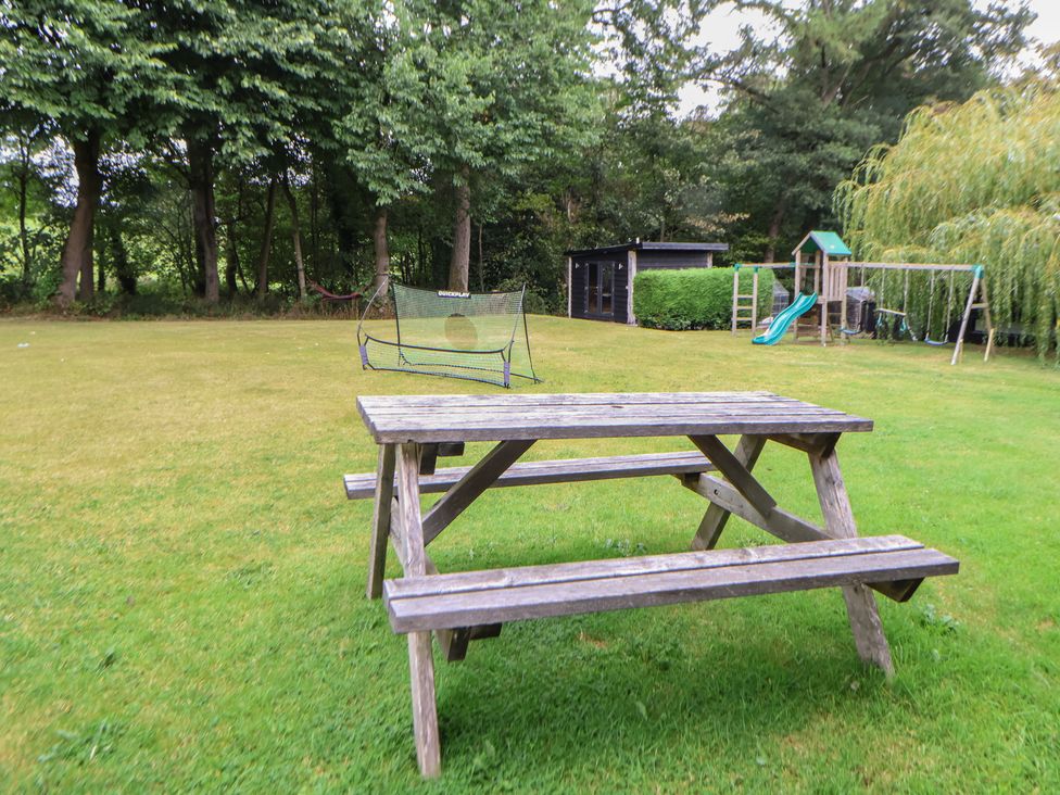 A garden with a picnic table, swing set, and goal net at Rook Hall Farm, Butterton near Newcastle-Under-Lyme