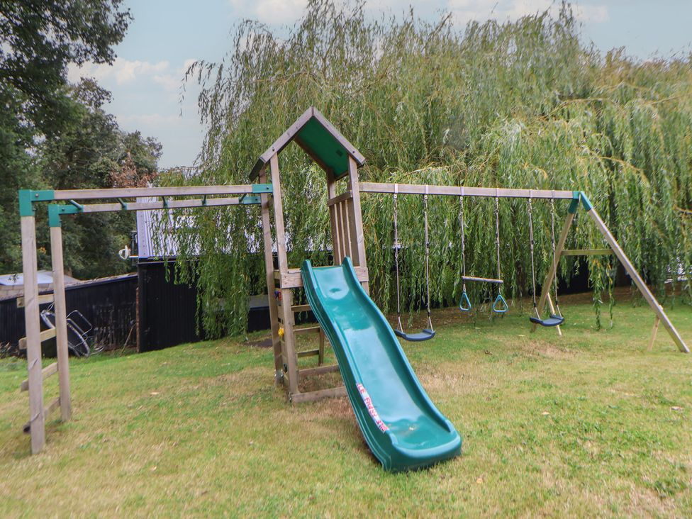 A playset with slide and swings in a garden at Rook Hall Farm Butterton near Newcastle-Under-Lyme