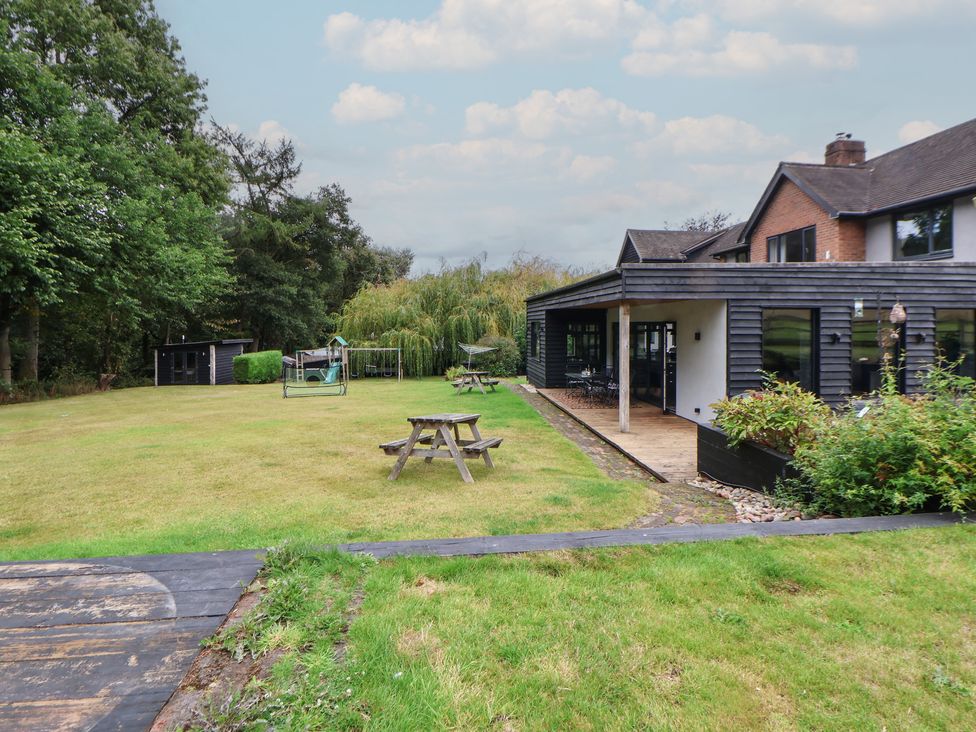 A garden with a table and swing at Rook Hall Farm in Butterton near Newcastle-Under-Lyme