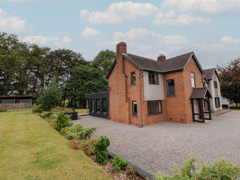 A house with a gravel driveway and gardens at Rook Hall Farm in Butterton near Newcastle-Under-Lyme