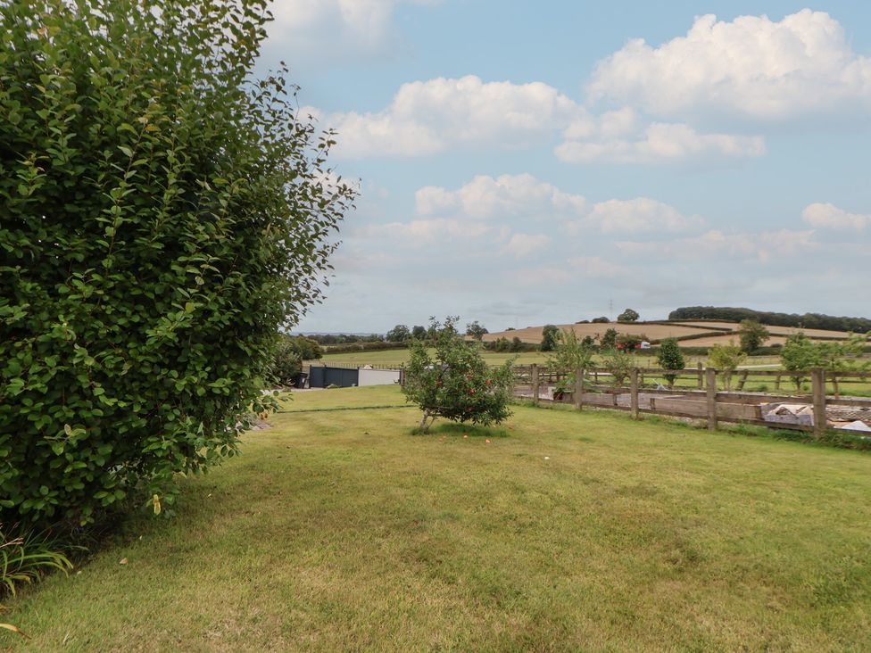 A garden with a tree and fence at Rook Hall Farm Butterton near Newcastle-Under-Lyme
