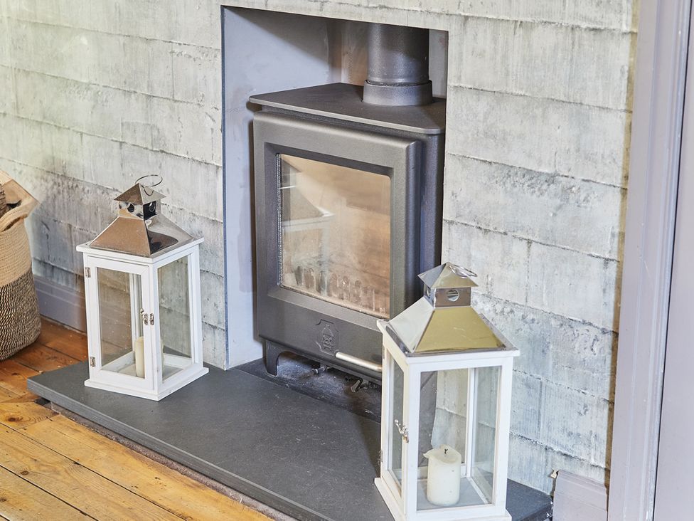 A living room with a fireplace and lanterns at Rook Hall Farm in Butterton near Newcastle-Under-Lyme