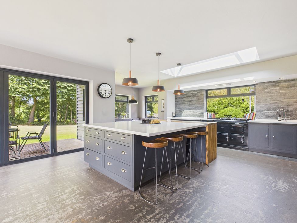 A kitchen with an island and bar stools at Rook Hall Farm near Newcastle-Under-Lyme