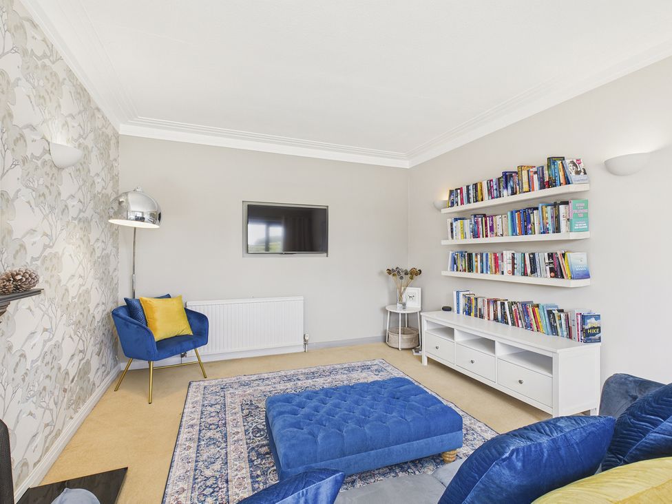 A living room with a TV and bookshelf at Rook Hall Farm Butterton near Newcastle-Under-Lyme