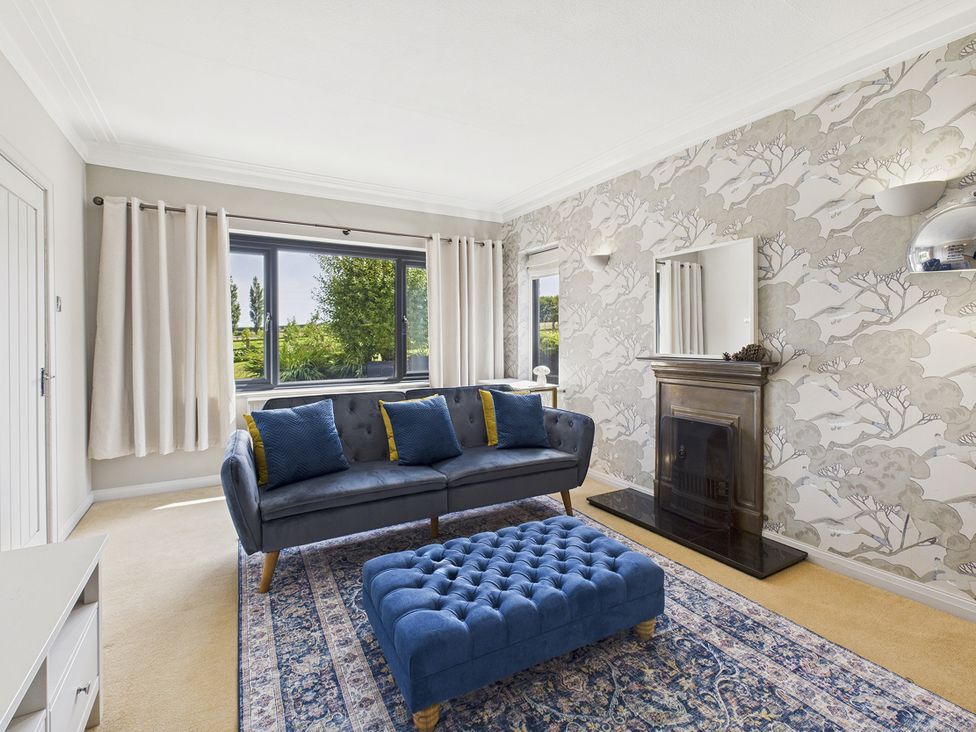 A living room with a blue sofa and footstool at Rook Hall Farm Butterton near Newcastle-Under-Lyme