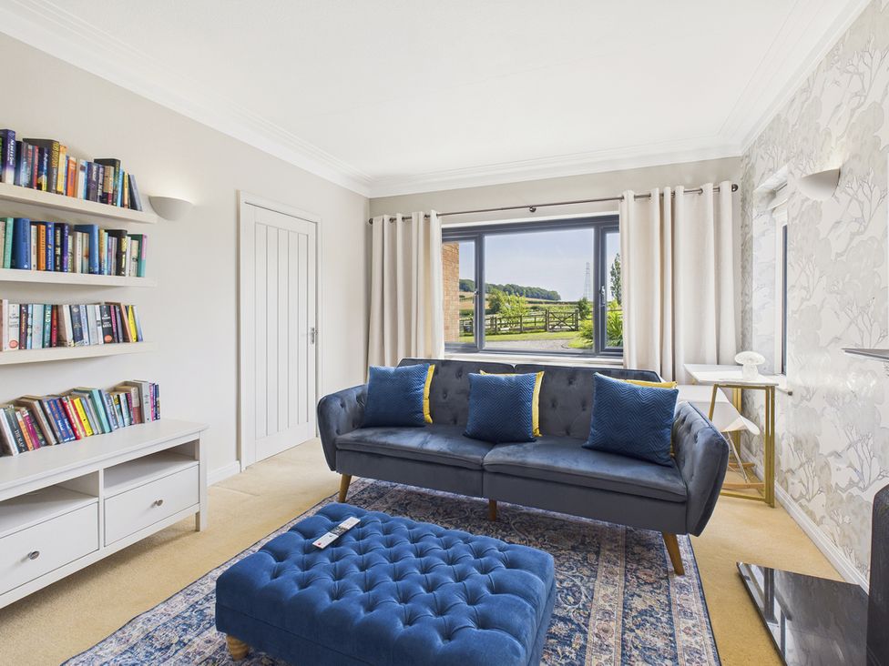 A living room with a bookshelf and sofa at Rook Hall Farm Butterton near Newcastle-Under-Lyme